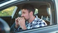 Hungry male driver eating snack in the car. Transport, food, lifestyle, people concept.