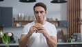 Hungry man eating burger at home kitchen. Starved guy enjoying cheeseburger Royalty Free Stock Photo