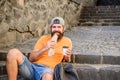 Hungry man snack. Junk food. Guy eating hot dog. Man bearded enjoy quick snack and drink paper cup. Street food so good