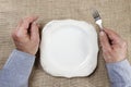 Hungry man waiting for his meal over empty plate