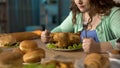 Hungry obese female preparing to dine with fatty roast chicken, stress eating