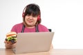 Hungry overweight woman smiling and holding a hamburger in the living room While work from home, her very happy and enjoy to eat