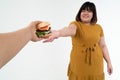 Hungry overweight young Asian woman holding hamburger on isolated background, Her hungry all time and overeat, gluttony and binge