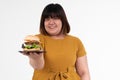 Hungry overweight young Asian woman holding hamburger on isolated background, Her hungry all time and overeat, gluttony and binge