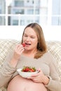 Hungry pregnant woman eating strawberries- Royalty Free Stock Photo