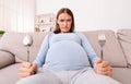 Hungry Pregnant Woman Holding Spoon And Fork Sitting On Couch Royalty Free Stock Photo