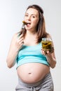 Hungry pregnant woman with a jar of pickled cucumbers against a Royalty Free Stock Photo