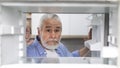 Hungry Senior Man Looking At Empty Shelves In Fridge At Home Royalty Free Stock Photo