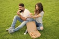 Hungry students sharing food. Pure enjoyment. Couple eating pizza relaxing on green lawn. Fast food delivery. Bearded