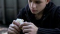 Hungry teen boy eating cheap unhealthy sandwich, poor quality meal for child Royalty Free Stock Photo