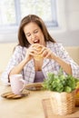 Hungry woman biting into sandwich