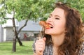 Hungry young woman eating meat on fork over house