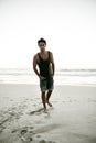 Hunk on a solitary stroll. Full length shot of a handsome young man at the beach. Royalty Free Stock Photo