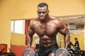 Hunky muscular black bodybuilder working out in