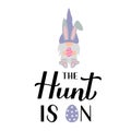 The hunt is on calligraphy hand lettering with cute gnome bunny holding egg. Funny Easter quote typography poster. Vector template Royalty Free Stock Photo