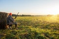 hunter with a gun in the field at dawn. Royalty Free Stock Photo
