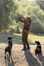 A hunter with a gun in his hands in hunting clothes in the autumn forest in search of a trophy. Royalty Free Stock Photo