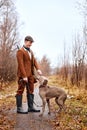 hunter guy with beautiful strong dog of Weimaraner breed on early autumn landscape Royalty Free Stock Photo