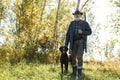 Hunter and his dog looking for trophy in forest Royalty Free Stock Photo