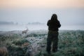 Hunter holding a rifle and aiming red deer, hunter photoshooting. Royalty Free Stock Photo