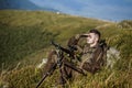 Hunter with hunting gun and hunting form to hunt. Hunter is aiming. Shooter sighting in the target. The man is on the Royalty Free Stock Photo