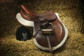 Hunter/jumper saddle and hunt cap on bales of straw Royalty Free Stock Photo