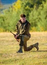 Hunter khaki clothes ready to hunt hold gun mountains background. Hunting shooting trophy. Hunter with rifle looking for Royalty Free Stock Photo