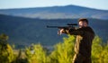 Hunter khaki clothes ready to hunt hold gun mountains background. Hunter with rifle looking for animal. Hunting shooting Royalty Free Stock Photo