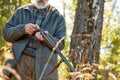 Hunter loading rifle in autumn forest