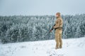 Hunter man dressed in camouflage clothing standing in the winter