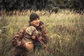 Hunter man with hunting dog Weimaraner in tall grass in rural field during hunting Royalty Free Stock Photo