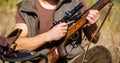 Hunter man. Hunting period. Male with a gun, rifle. Man is charging a hunting rifle. Close up. Process of hunting during