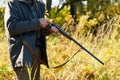 Hunter loading rifle in autumn forest