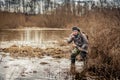 Hunter man wading through the swamp lurking in the bushes and shows gesture to be quiet Royalty Free Stock Photo