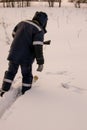 hunter or poacher with a weapon approaches on skis to fresh bird tracks in the snow