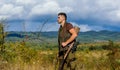 Hunter rifle gun stand top of mountain. Guy bearded hunter spend leisure hunting on birds. Hunting hobby concept. Man Royalty Free Stock Photo