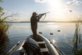 hunter shooting to the flying duck at sunrise Royalty Free Stock Photo