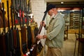 Hunter at showcase with hunting rifles, gun store Royalty Free Stock Photo