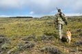 Hunter and tracking dog hiking on wild plain Royalty Free Stock Photo