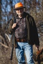 Elderly hunter with wild bird in orange hat Royalty Free Stock Photo