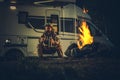 Hunter Wearing Camouflage Coating Burning Campfire Next to His Motorhome Camper Van RV