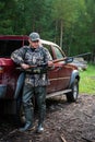 Hunter wearing glasses and camouflage with weapon shotgun at the outdoor hunting