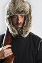 Hunter winter fur hat man holding gun Royalty Free Stock Photo