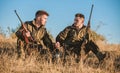 Hunters with rifles relaxing in nature environment. Hunting with friends hobby leisure. Hunters satisfied with catch