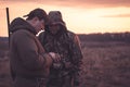 Hunters spot their position via smartphone in rual field during hunting season Royalty Free Stock Photo