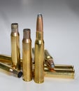 Hunting ammunition and empty rifle bullet cartridges on white.