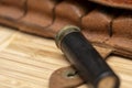 Hunting cartridge on the background of a leather bandolier on a textured background, close-up, selective focusing. Concept: bird h