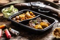 Hunting eddititon lunch in portable take away plastic box consisting of delicious roasted potatoes with wild game goulash stew and