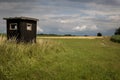 Hunting hide in field with tree in background Royalty Free Stock Photo