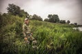 Hunting hunter man hiding in reed swamp tall grass during hunting season